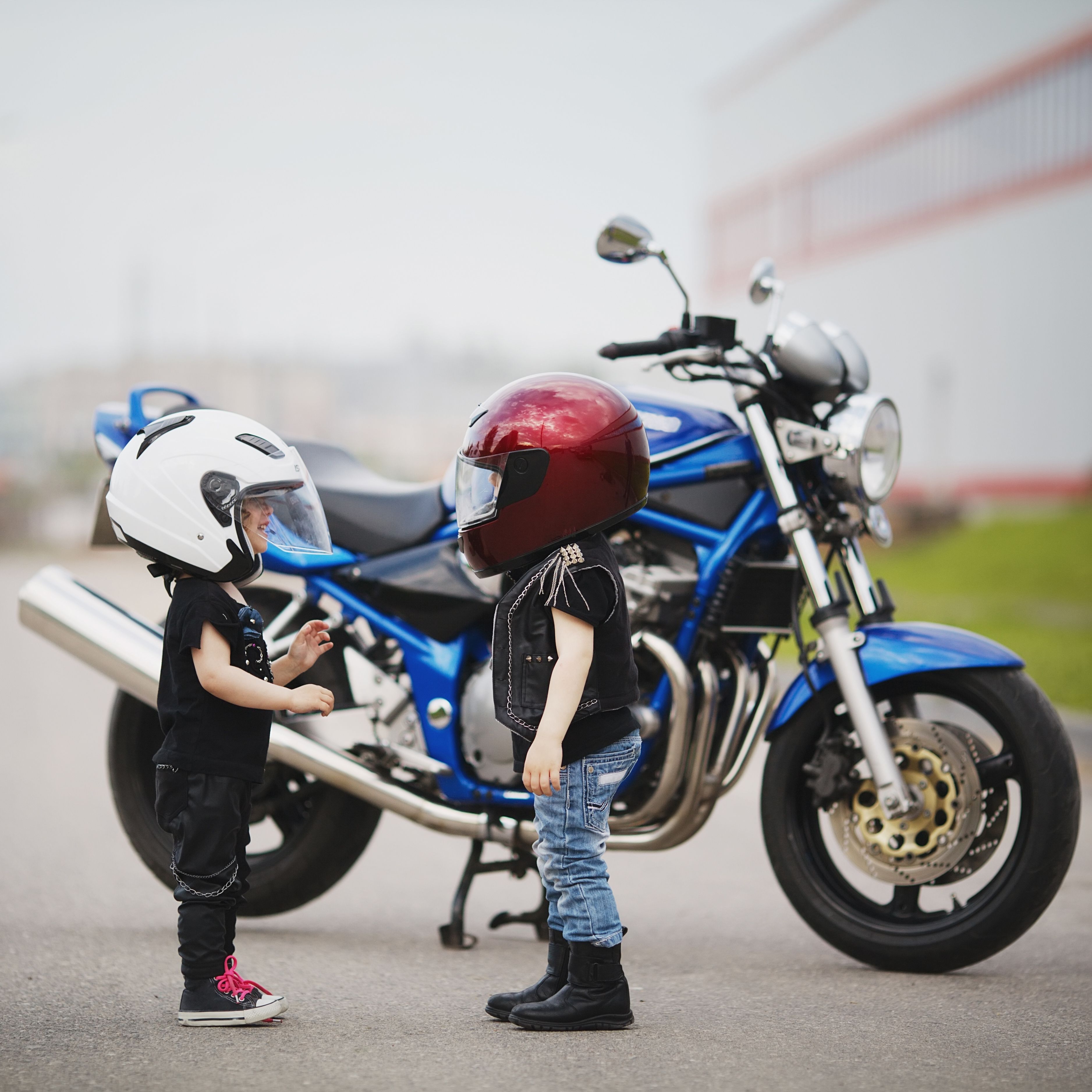 Zwei Kinder mit Helm vor Motorrad