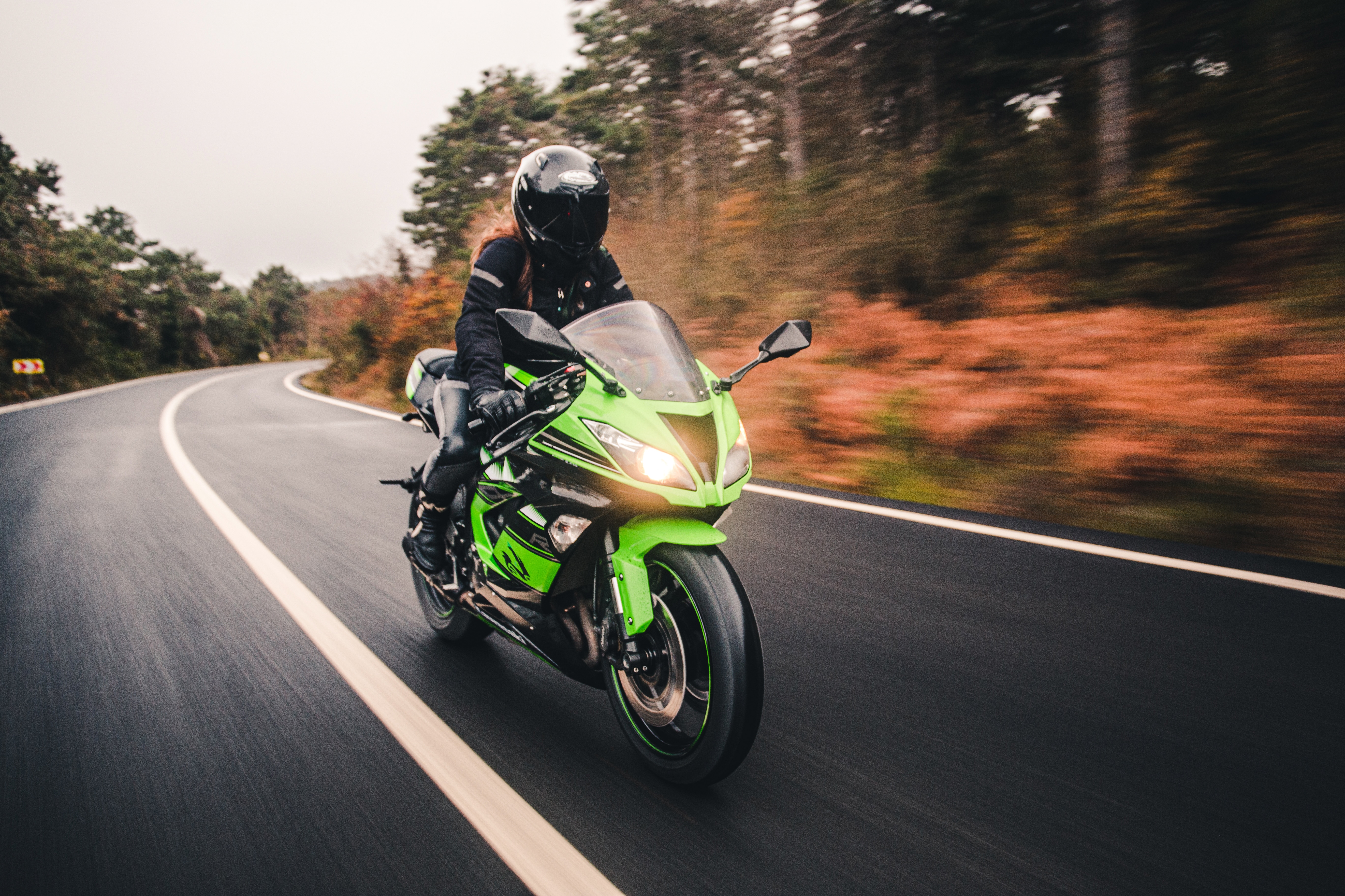 Neon grünes Motorrad fährt auf einer Landstraße